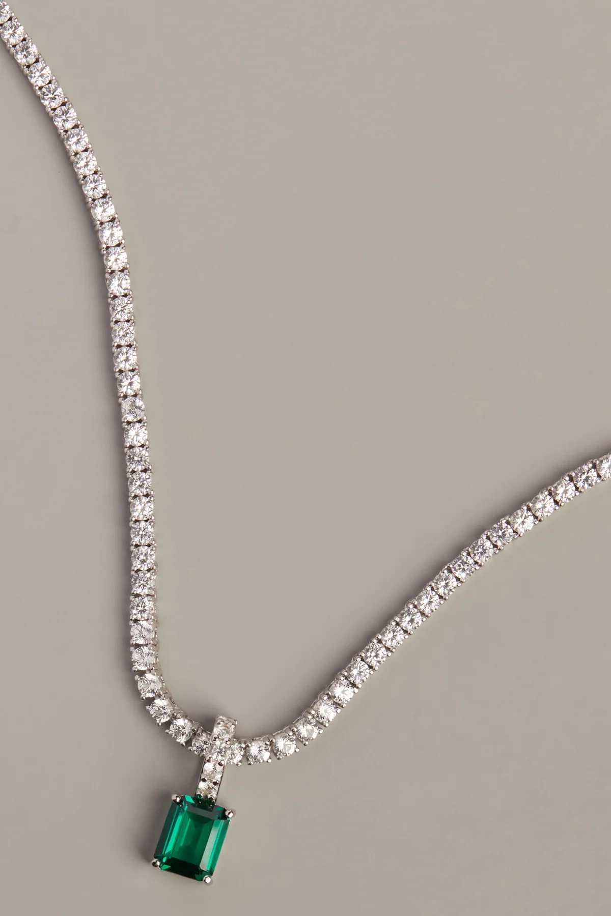 Sidra tennis necklace in 18k white gold with an emerald-cut green pendant